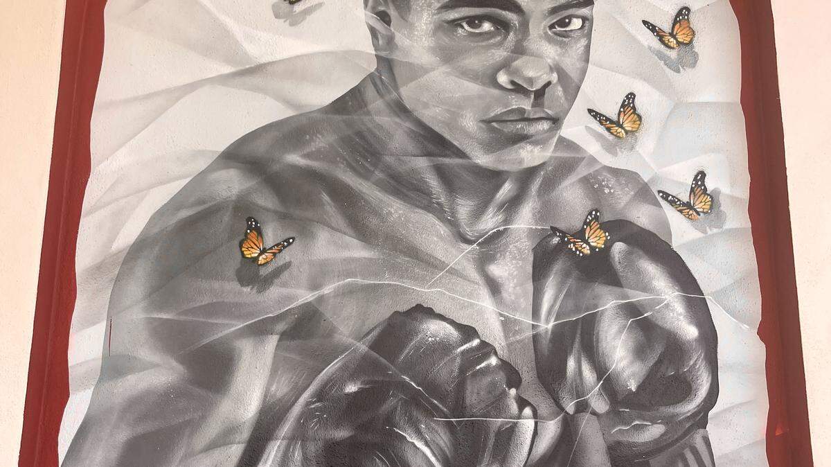 This year’s Windows to Our World murals depict Muhammad Ali and three other figures with a new augmented reality feature.
