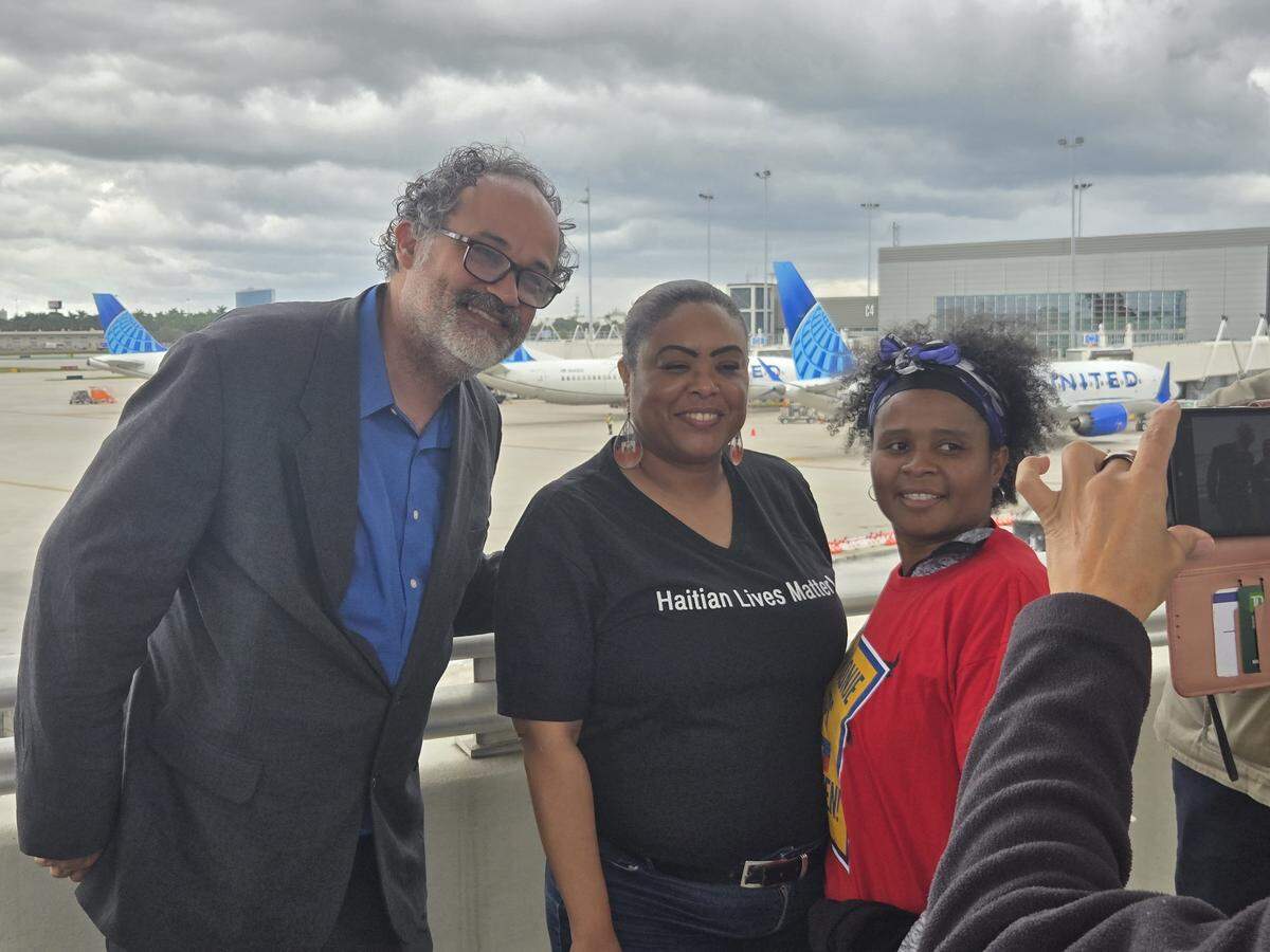 Farah Larrieux (center) showed support for airport workers at a demonstration demanding an extension for Haitian TPS.