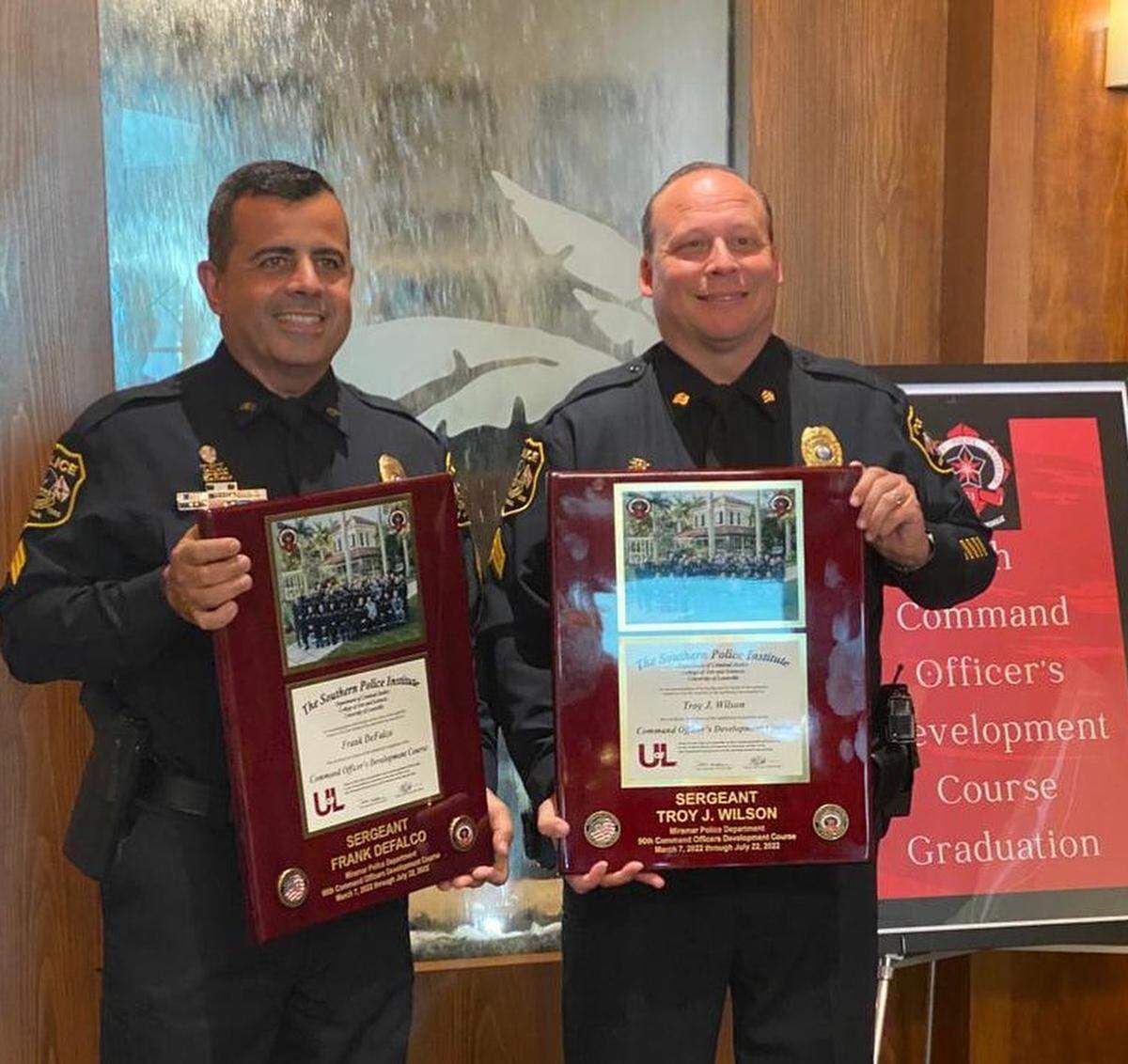 Former Miramar Police Sgt. Troy Wilson, right, posing for a photograph following the presentation of a commendation. Also pictured, Sgt. Frank DeFalco.